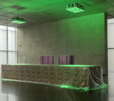Desk constructed of Amazon shipping boxes covered with plastic foil in the green LED lighted exhibition space at the first floor of Kunsthaus Bregenz