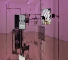 A pink room with screens suspended from polls.