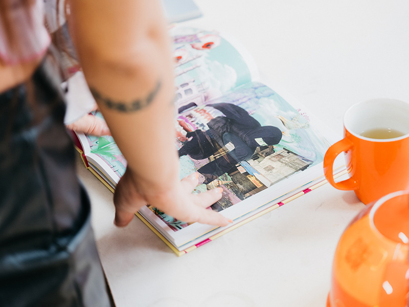 Close up of a woman's arm touching a book on a desk