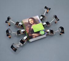 A small robot made from a book on the Mona Lisa with six robotic legs attached
