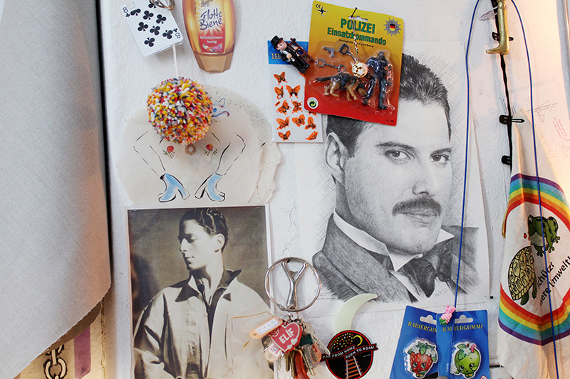 A close-up of Elif Saydam's studio wall with a drawn picture of Freddy Mercury, stickers and knickknacks