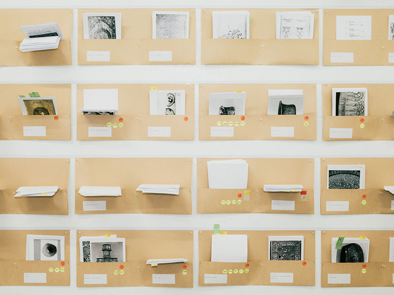 A wall with folders pinned to it in a grid