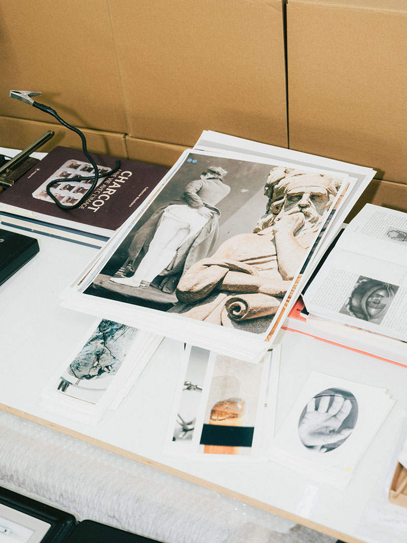 a close-up of an artist's desk with photographs and books on it