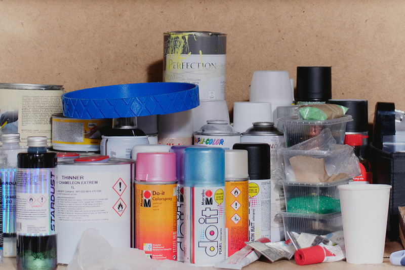 A close-up of spray paint bottles on a shelf