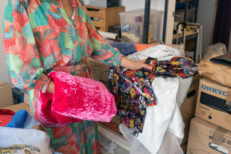 a close-up of a woman's hands holding a variety of colourful textiles