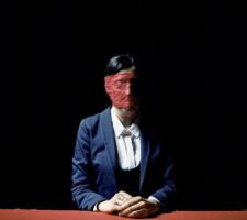 Woman in a suit blindfolded with red lace