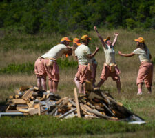 a photograph of a group of people dancing in a field
