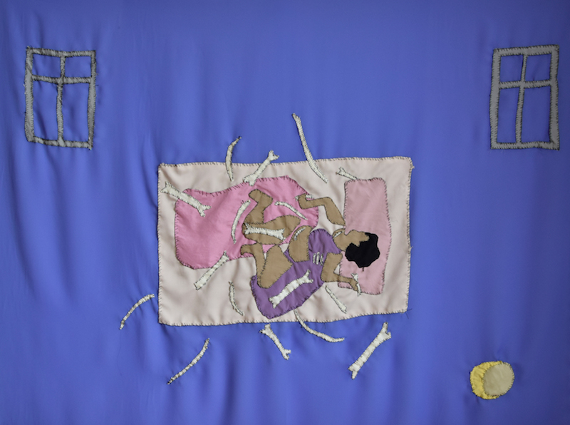 a textile piece with a women lying on a bed, covered in what appear to be bones