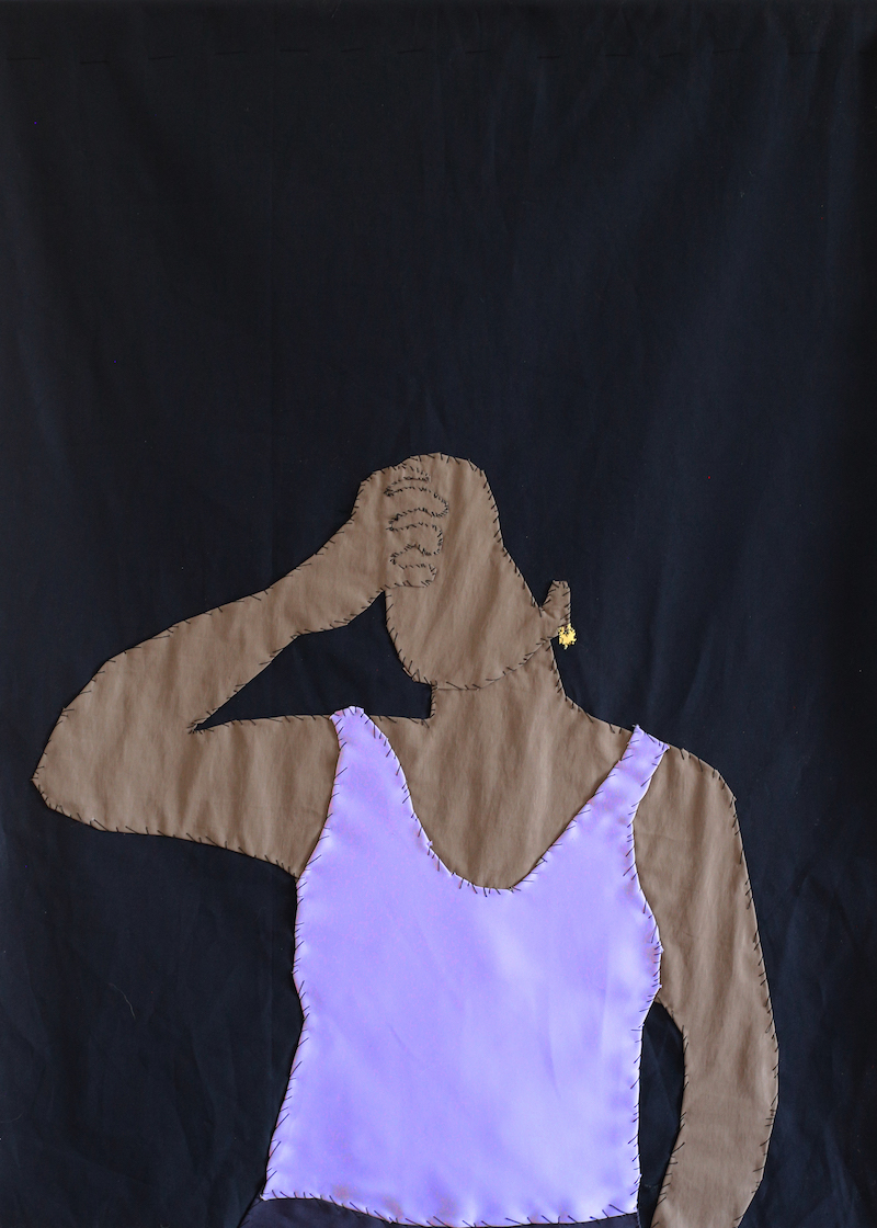 a textile work on black fabric with a brown skinned woman holding her hand to her forehead