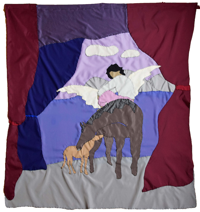 a colorful textile work of a woman rides on a donkey through a passage