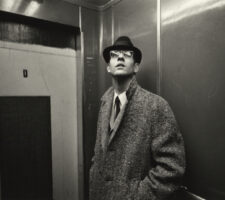 A fashionable man with a head and sun glasses in an elevator