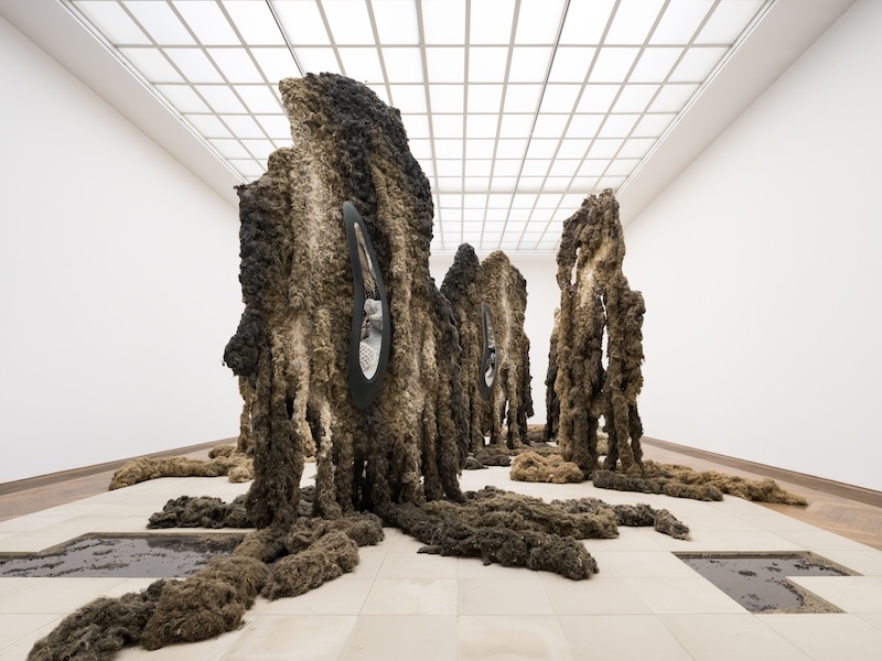 monumental installation with brown sculptures made of textile fibers