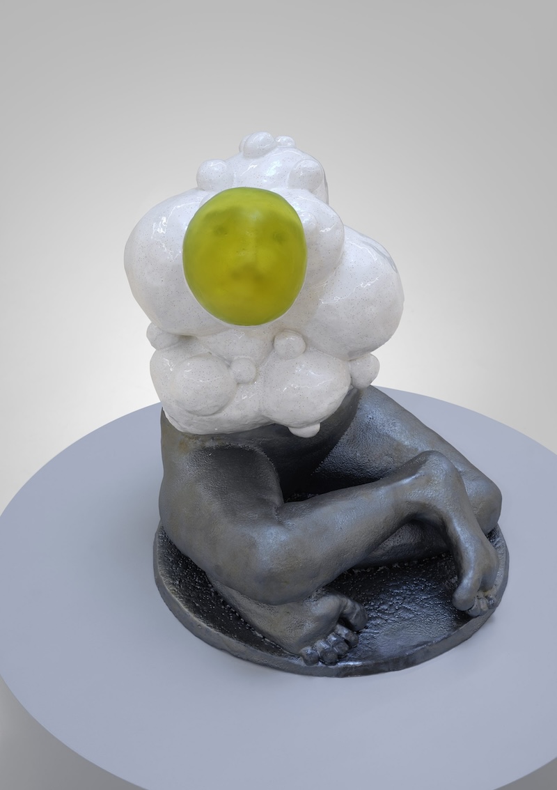 figure with silver crossed legs and a yellow face with white around